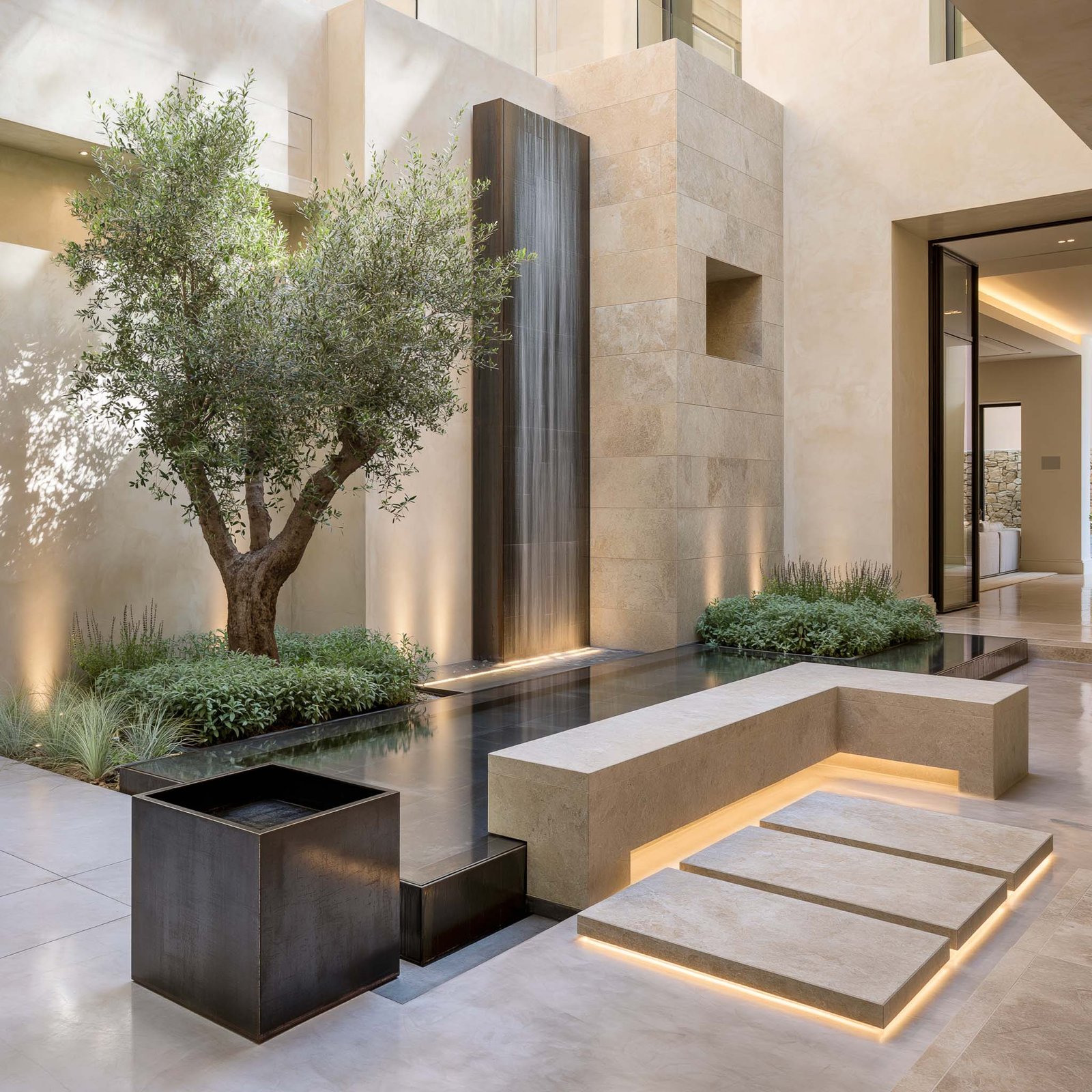 Son — cour intérieure méditerranéenne d’une villa à Roquebrune-Cap-Martin, long bassin réflectif bordé de pierre claire, jardinière cube en acier noirci avec olivier mature, présence sonore de l’eau qui structure le fond acoustique.