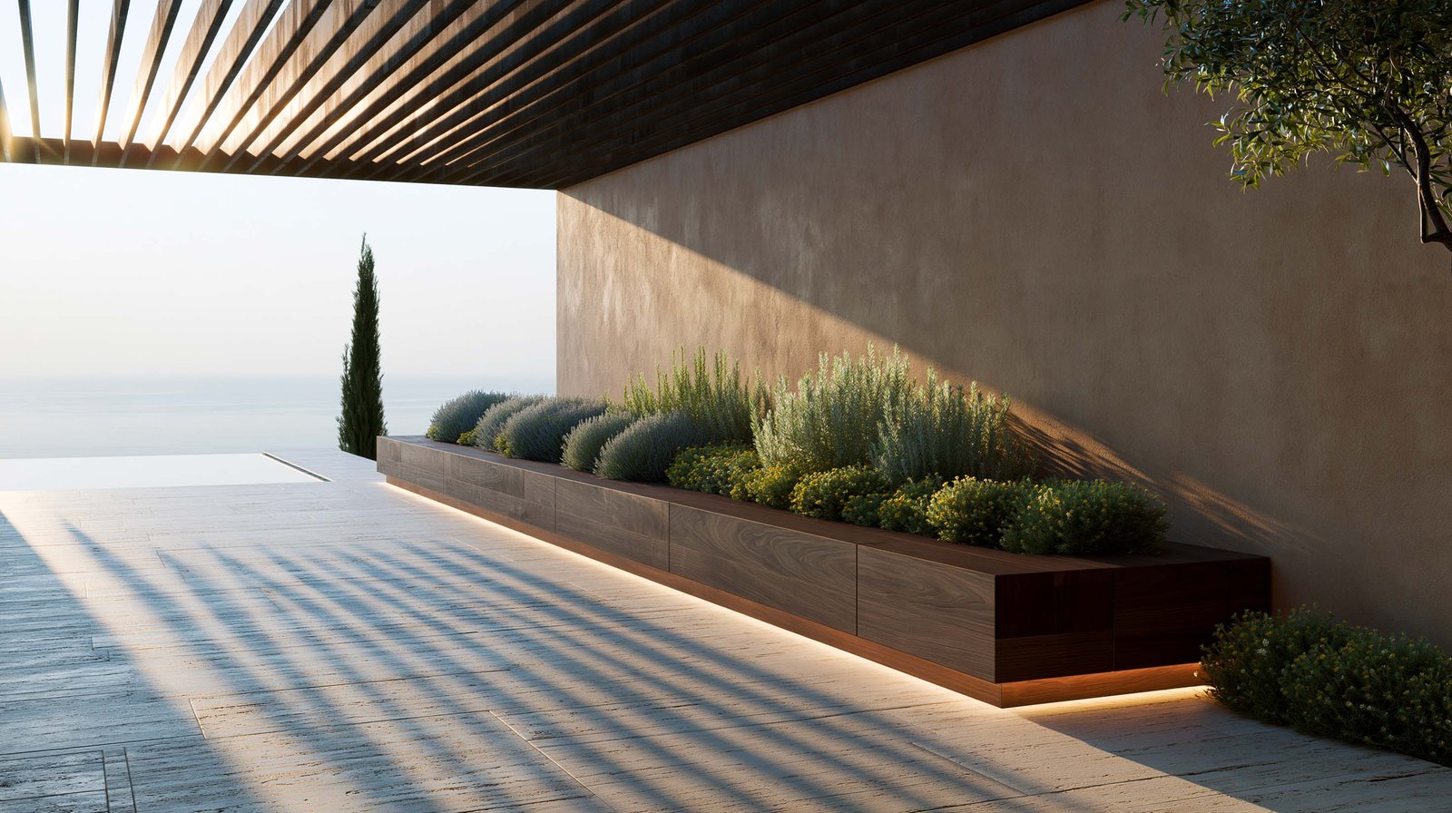 Terrasse panoramique d’une villa contemporaine à Èze au matin golden hour, pergola SylvaVeil™ en lames horizontales de noyer fumé filtrant le soleil rasant en stries d’ombre nettes sur le sol travertin clair warm honey, long planter Lignum™ Block en noyer fumé contre un mur en stucco lustro ocre patiné portant Rosmarinus officinalis, Phlomis fruticosa et Helichrysum italicum sous LED 2700K, Cupressus sempervirens stricta en silhouette devant la piscine miroir et l’horizon Méditerranée, Paracelsus Gardens™